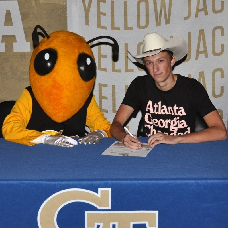 Photo of Stephen Nash at a signing table with Buzz.